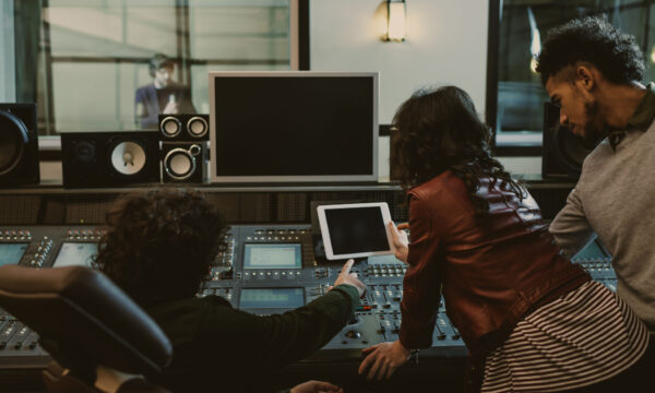 sound producers using tablet together at recording studio